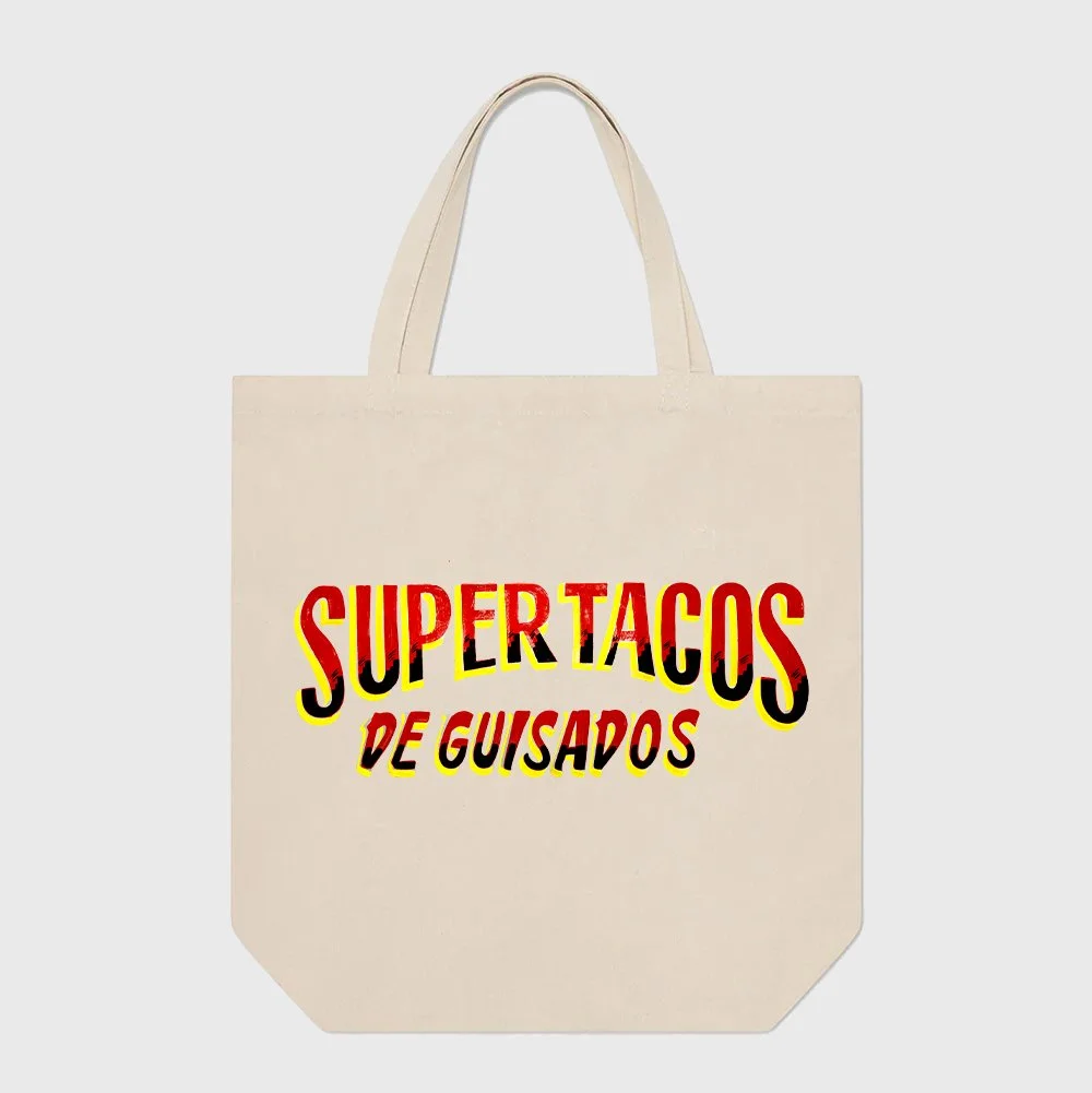 A beige tote bag with colorful text that reads 'SuperTacos de Guisados' in bold, red, black, and yellow font.