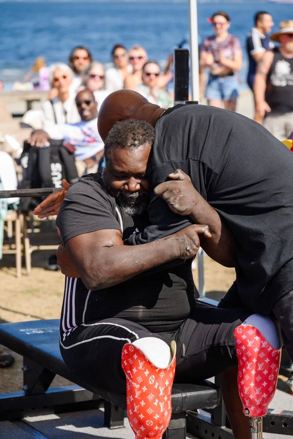 Bull Stewart hugging a disabled competitor at the Alki Beach powerlifting tournament