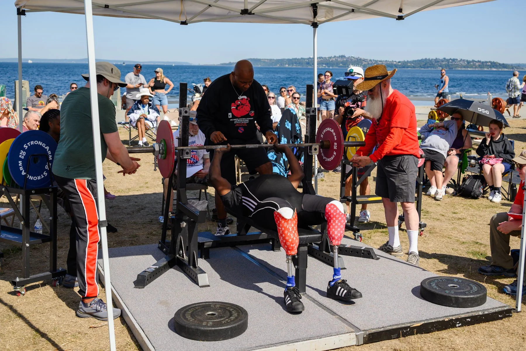 Bull and two trainers spotting a disable competitor at the Alki Beach powerlifting tournament