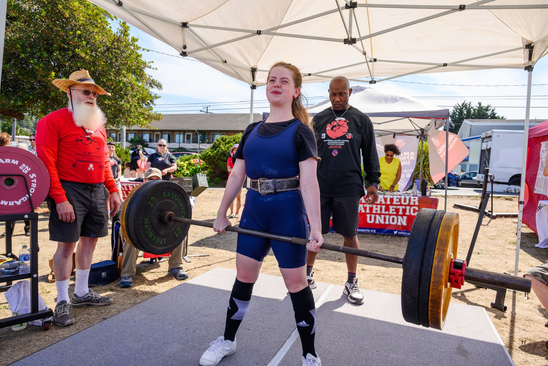 Young woman holding deadlift weight at Alki powerlifting tournament