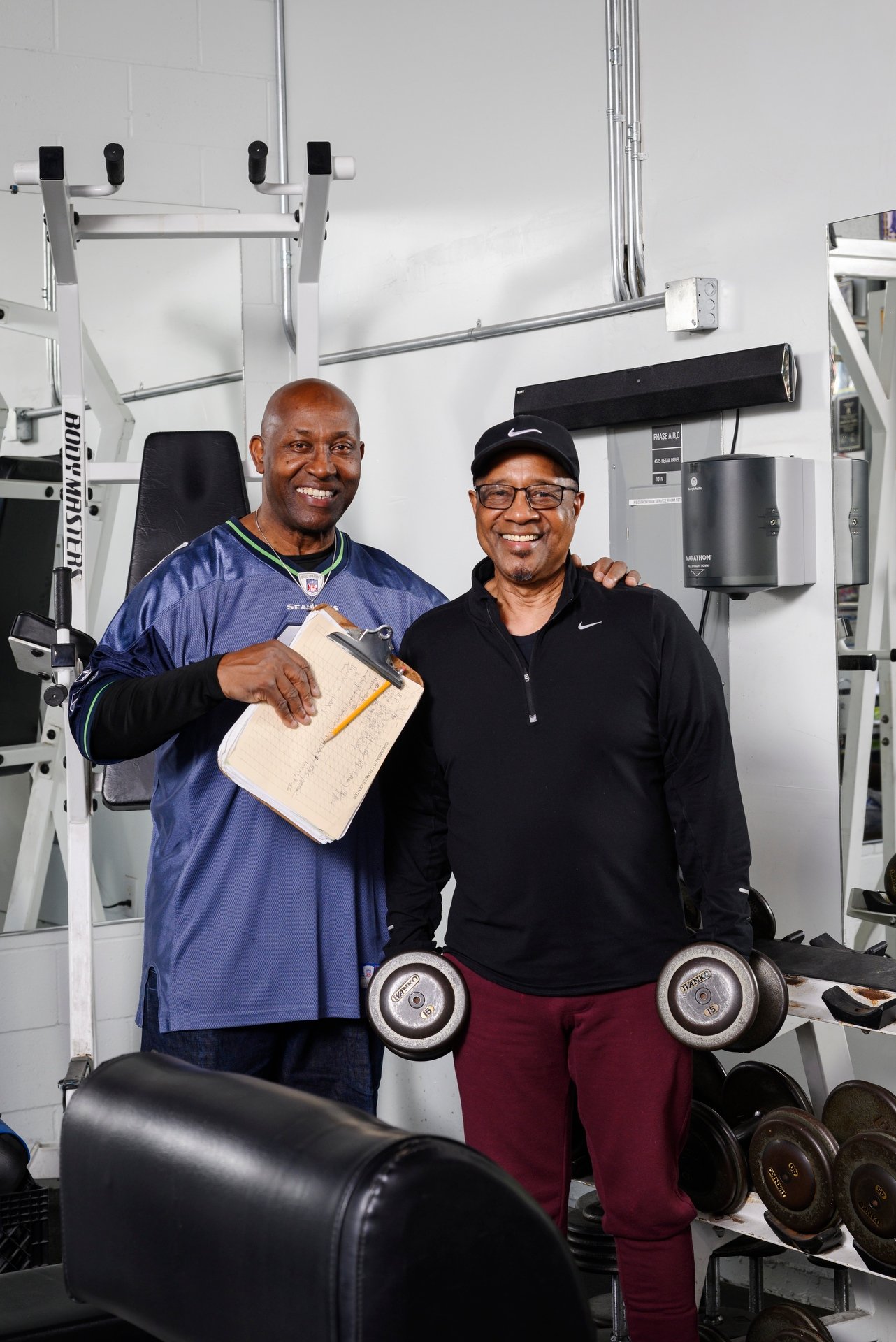 Bull Stewart smiling with an older gentleman holding dumbbells.