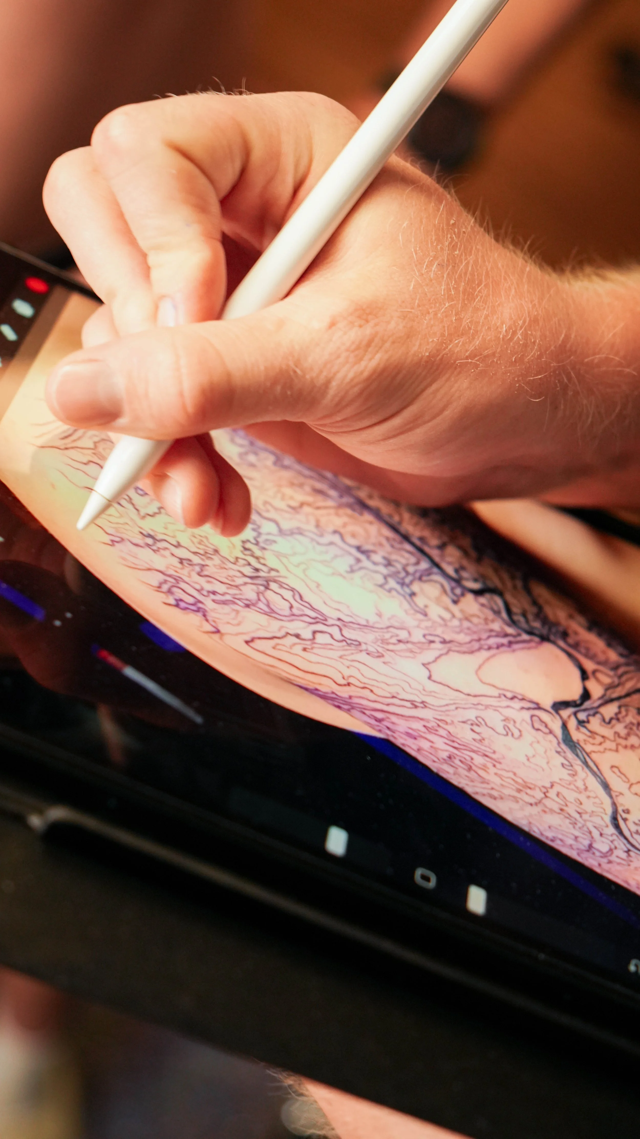 Person using a stylus on a digital drawing tablet with a colorful topographical map displayed.