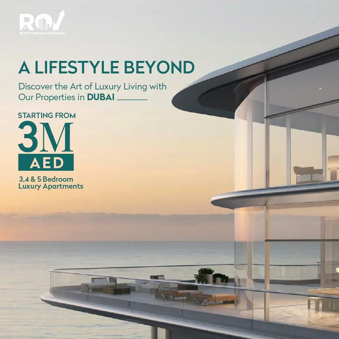Luxury modern building with large glass windows and outdoor balcony overlooking the ocean during sunset.