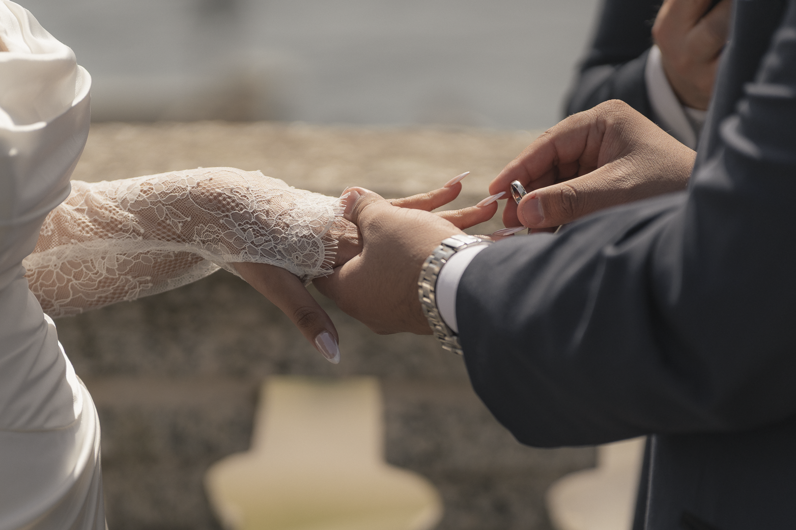 Una coppia sta scambiando gli anelli di nozze durante un matrimonio all'aperto.