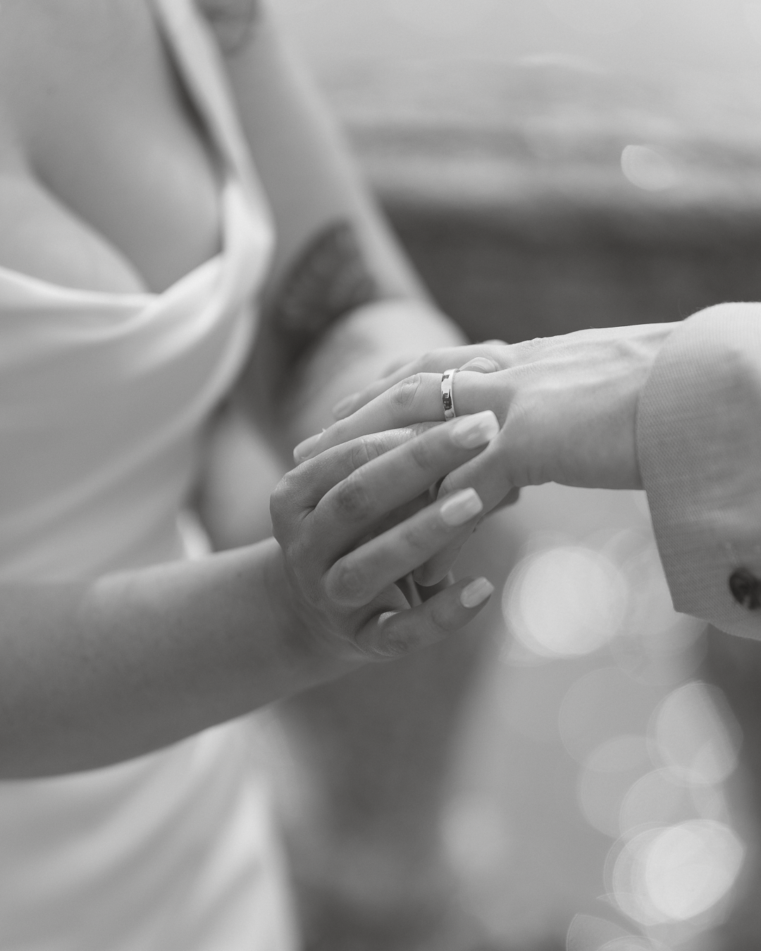 Due persone si tengono per mano, una delle quali indossa una fede nuziale.