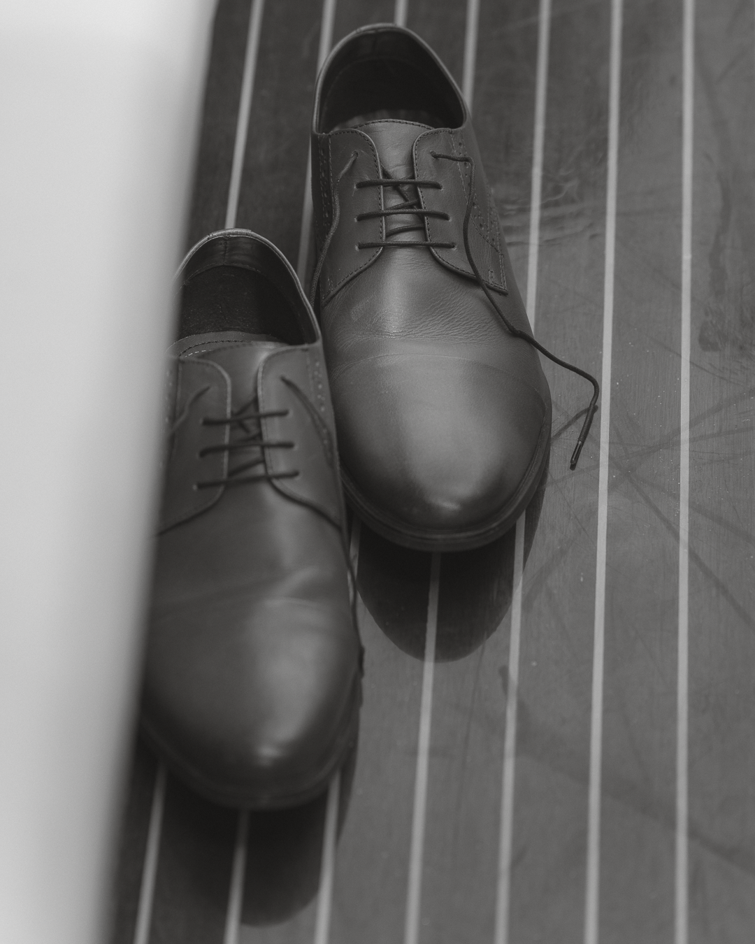 Scarpe da uomo nere eleganti appoggiate sul pavimento di piastrelle