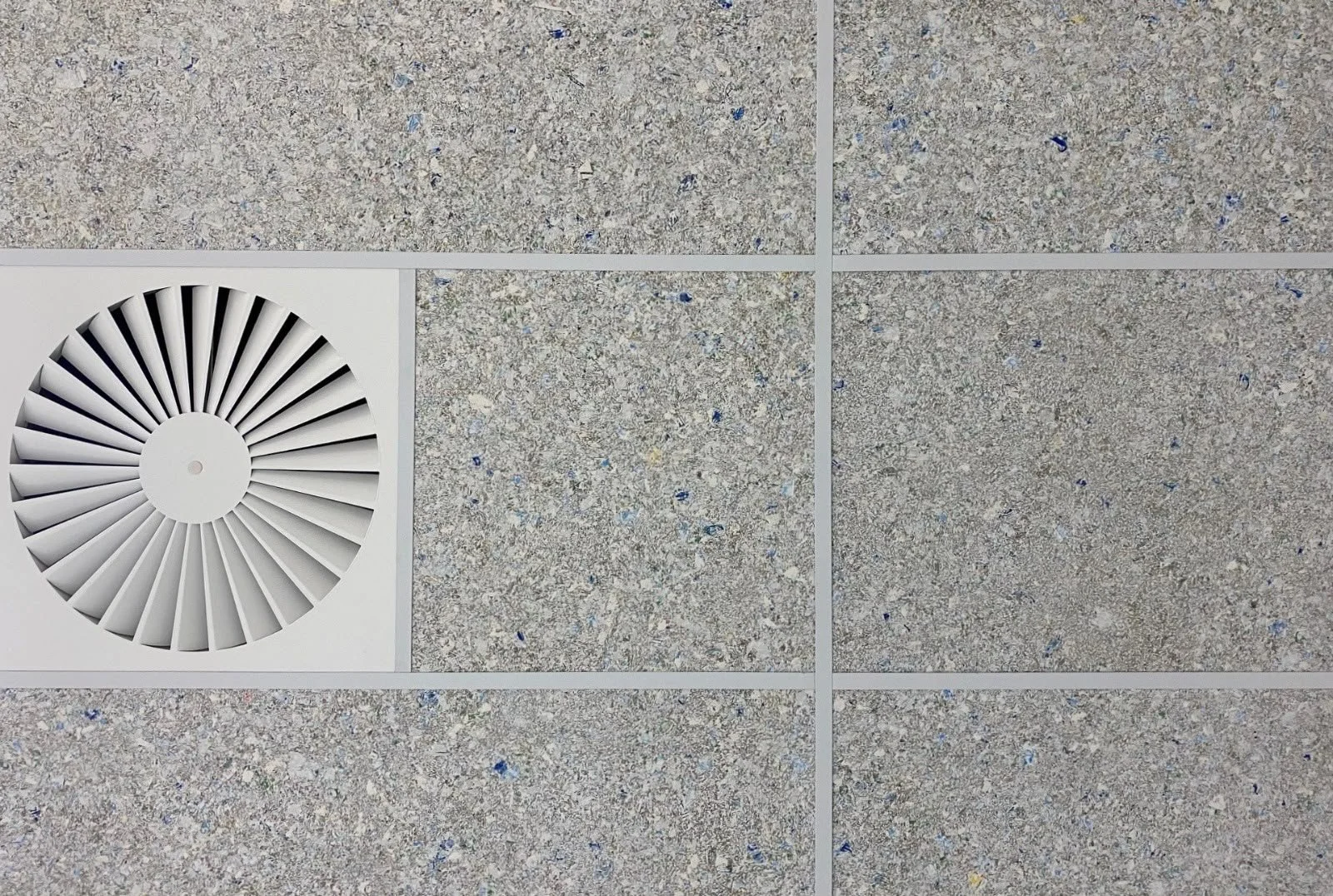 Ceiling tiles with a circular air vent in the lower left corner.