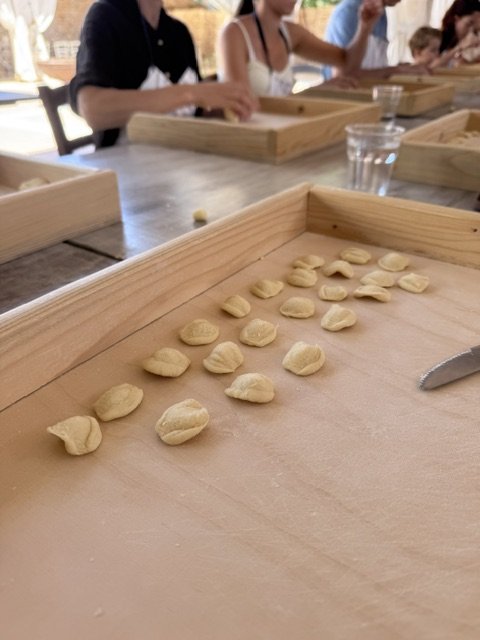Guests preparing handmade orecchiette together during a culinary workshop hosted by Vanessa & Carlo.