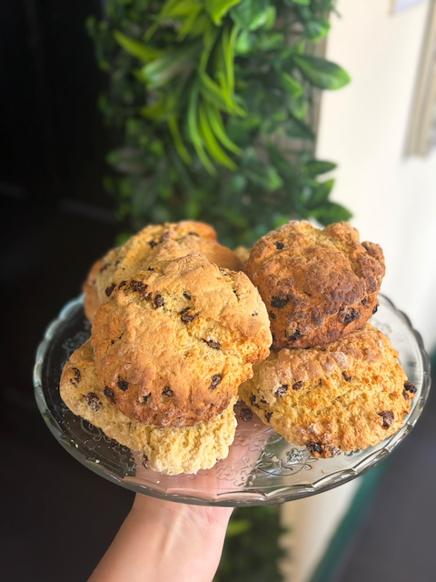 Glass cake stand holding a stack of homemade chocolate chip scones