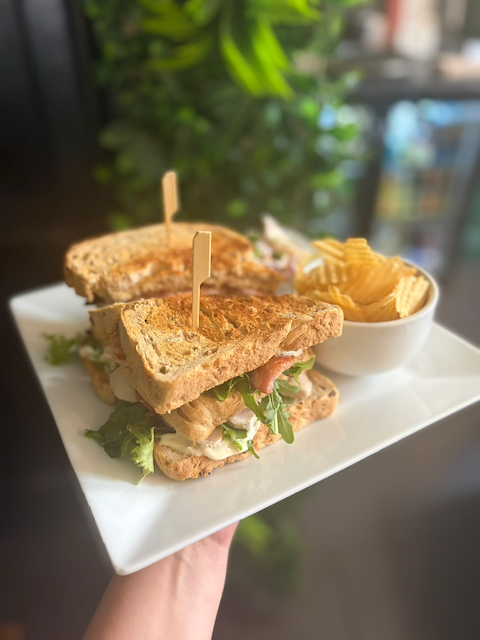 Grilled chicken sandwiches with lettuce and tomato served with crinkle-cut fries on a white plate