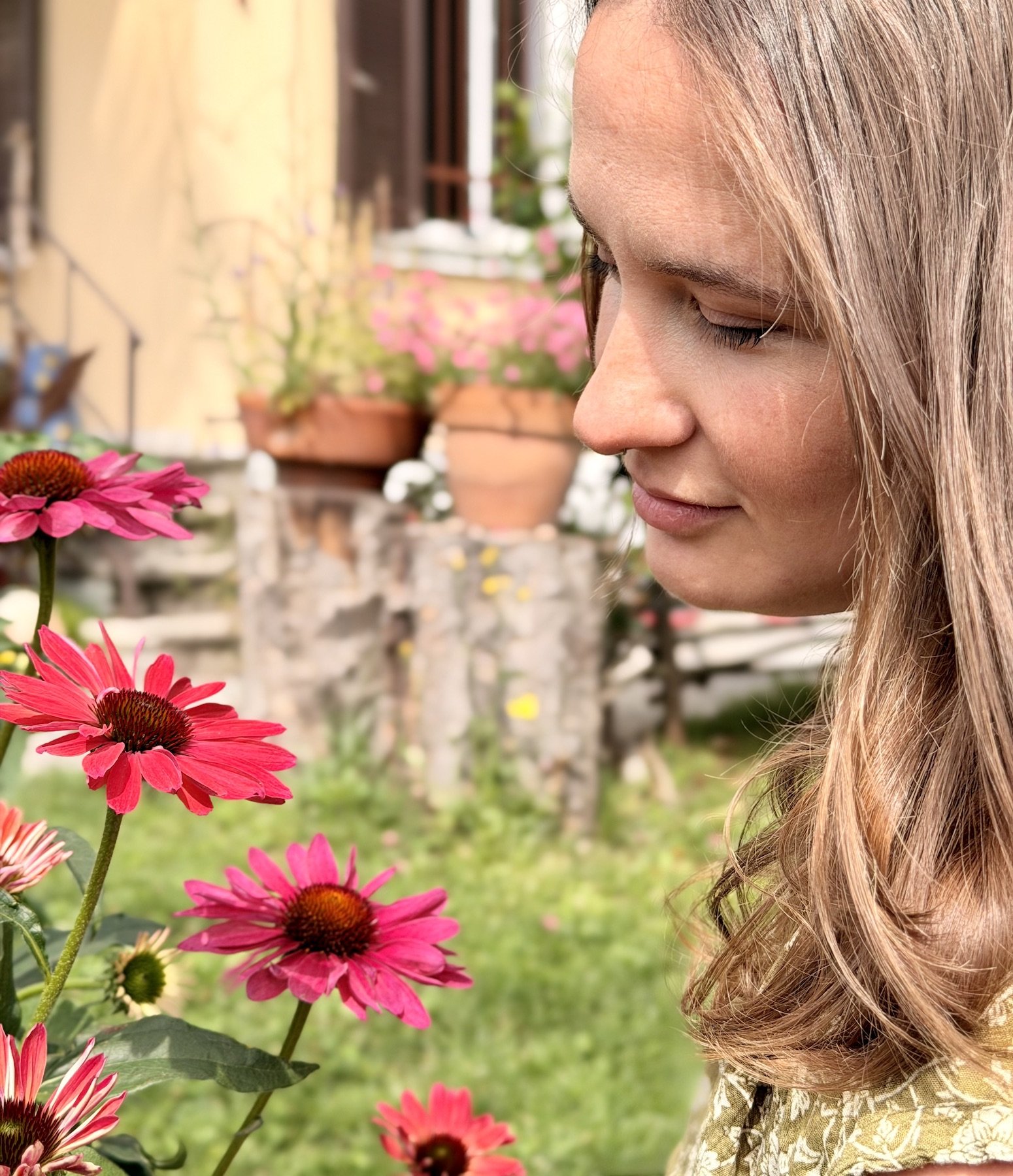 Alice Botanica observing Echinacea flowers in her garden before creating botanical watercolor paintings.