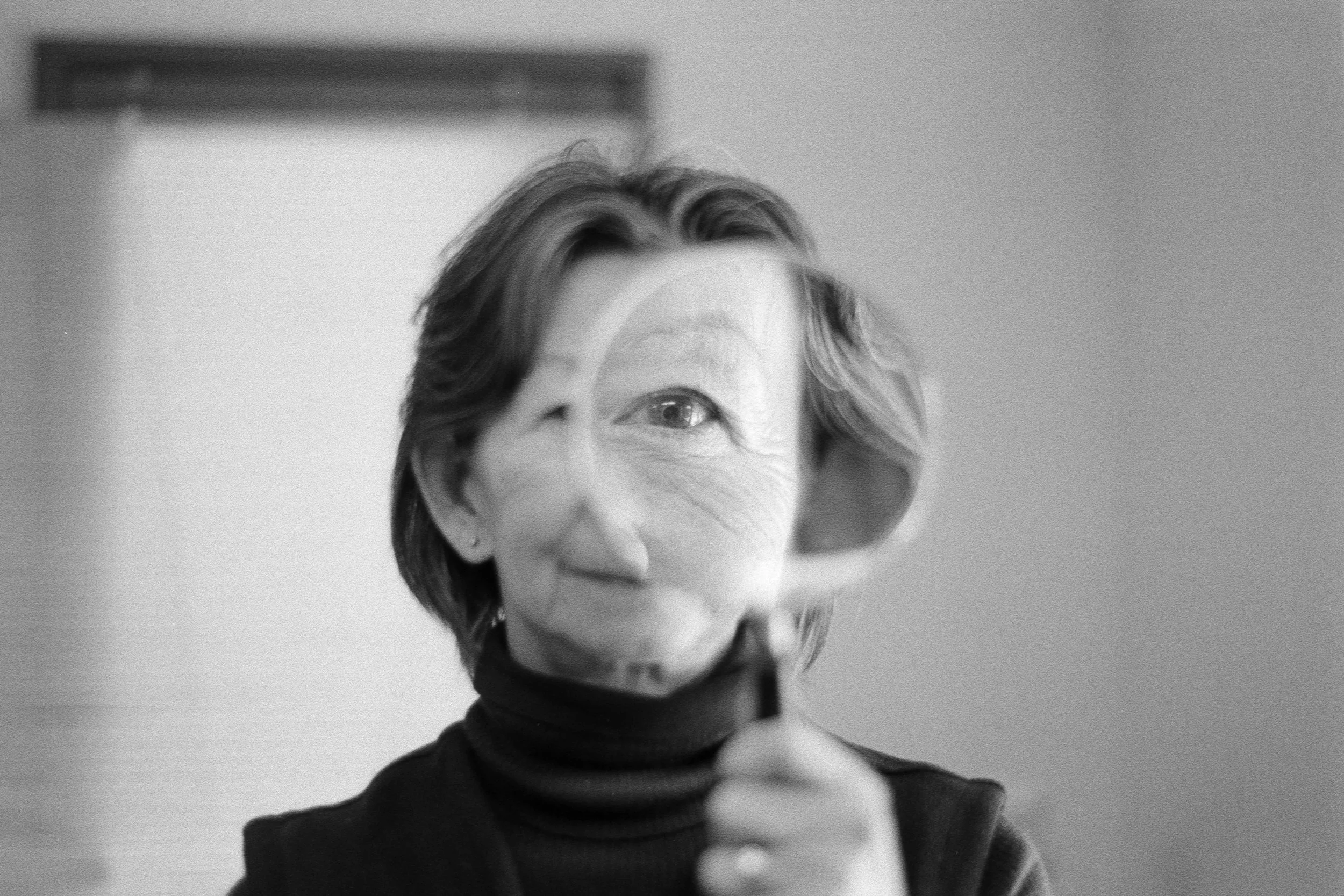Person looking through a magnifying glass, illustrating the search for a single cause of low back pain.