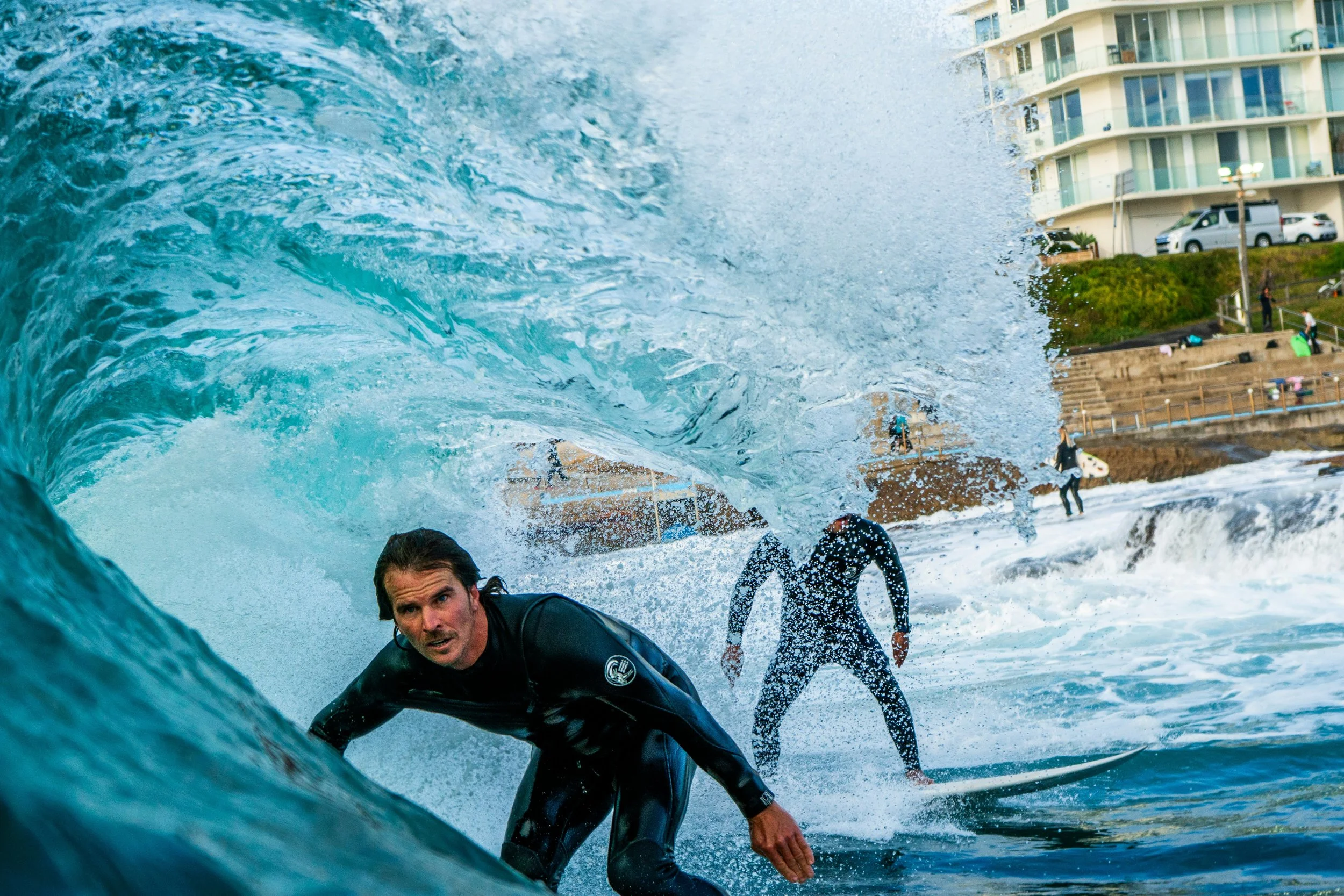 Surfer riding inside a wave representing persistent low back pain that can continue after the original injury has healed