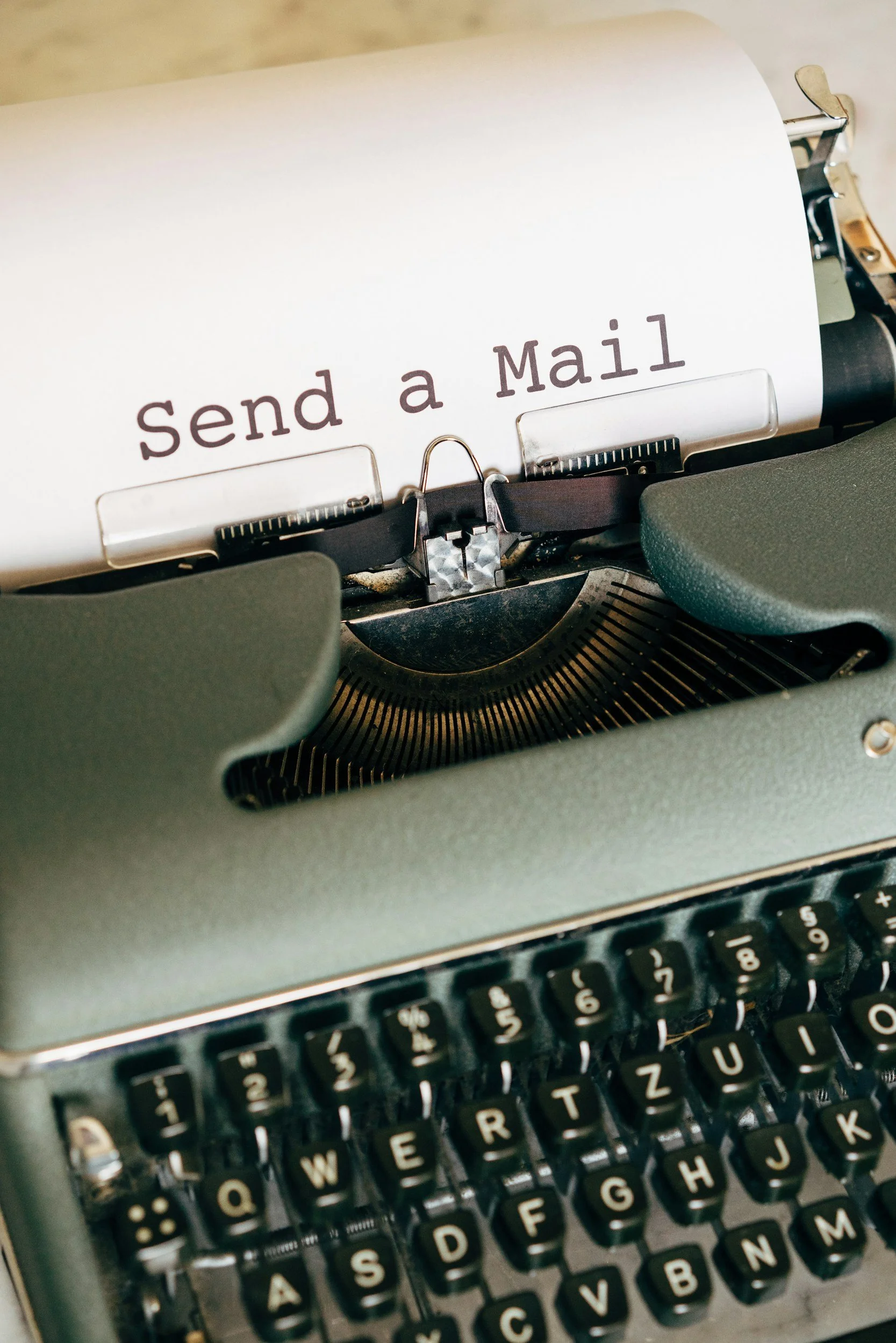 A vintage typewriter with a piece of paper that says 'Send a Mail'.