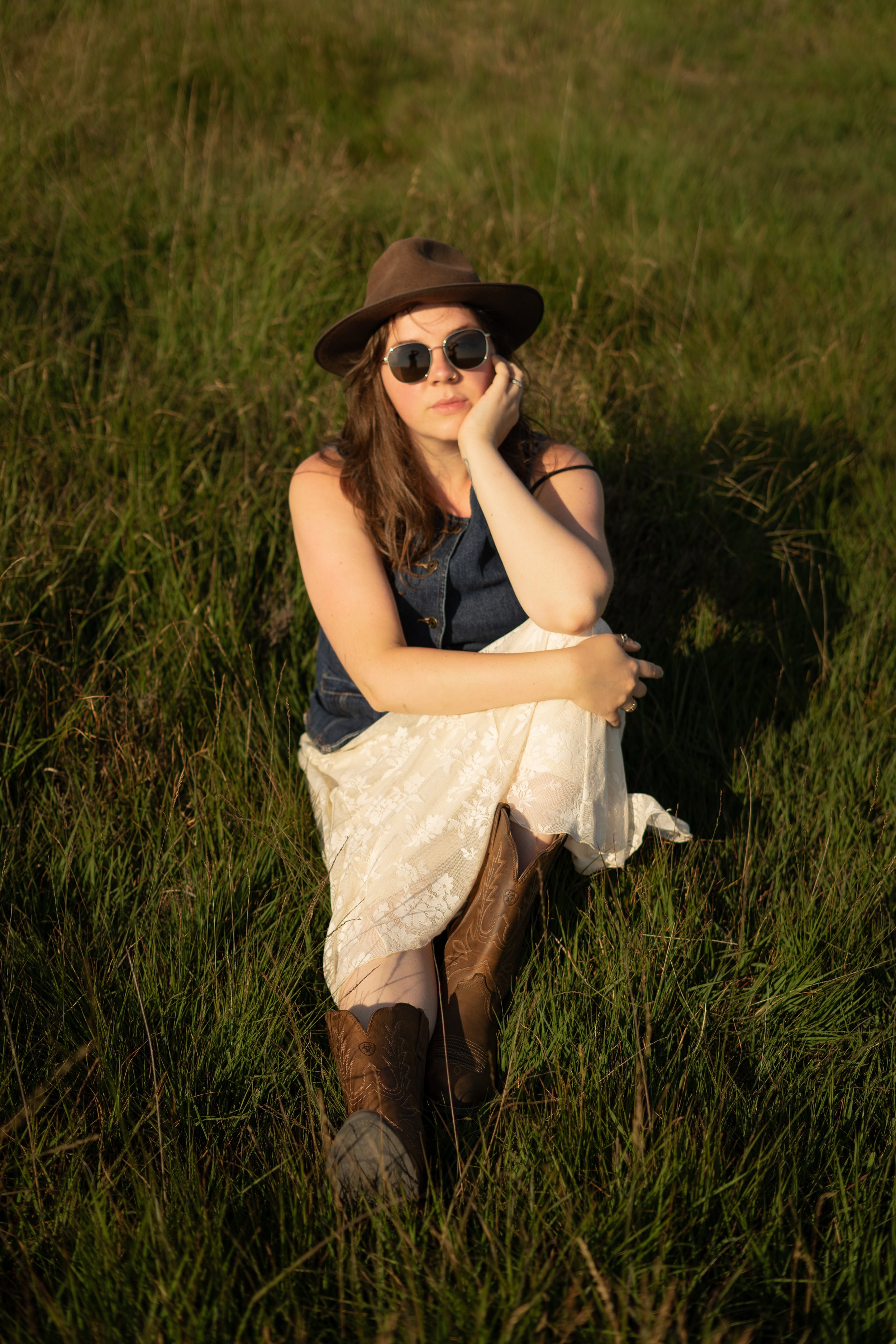 woman sat down looking at camera in field