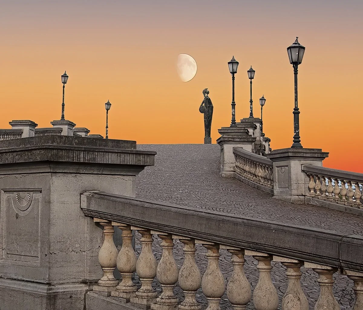 View of a stone bridge with decorative balustrades and lamp posts, a statue of a woman stands on the bridge, and the moon is visible in a colorful sunset sky.