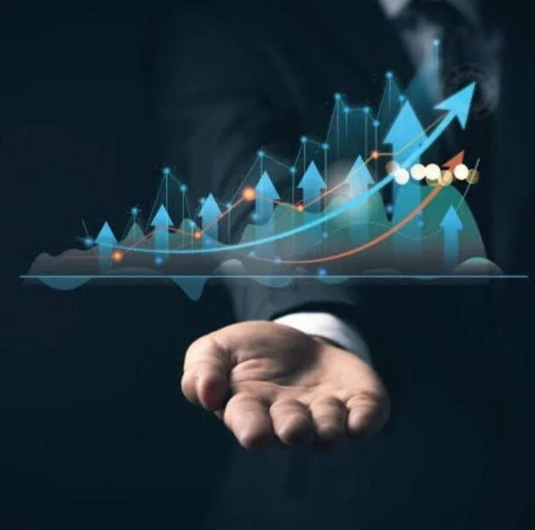 A business person's hand extended with a digital graph and upward arrows floating above it, symbolizing growth or success.
