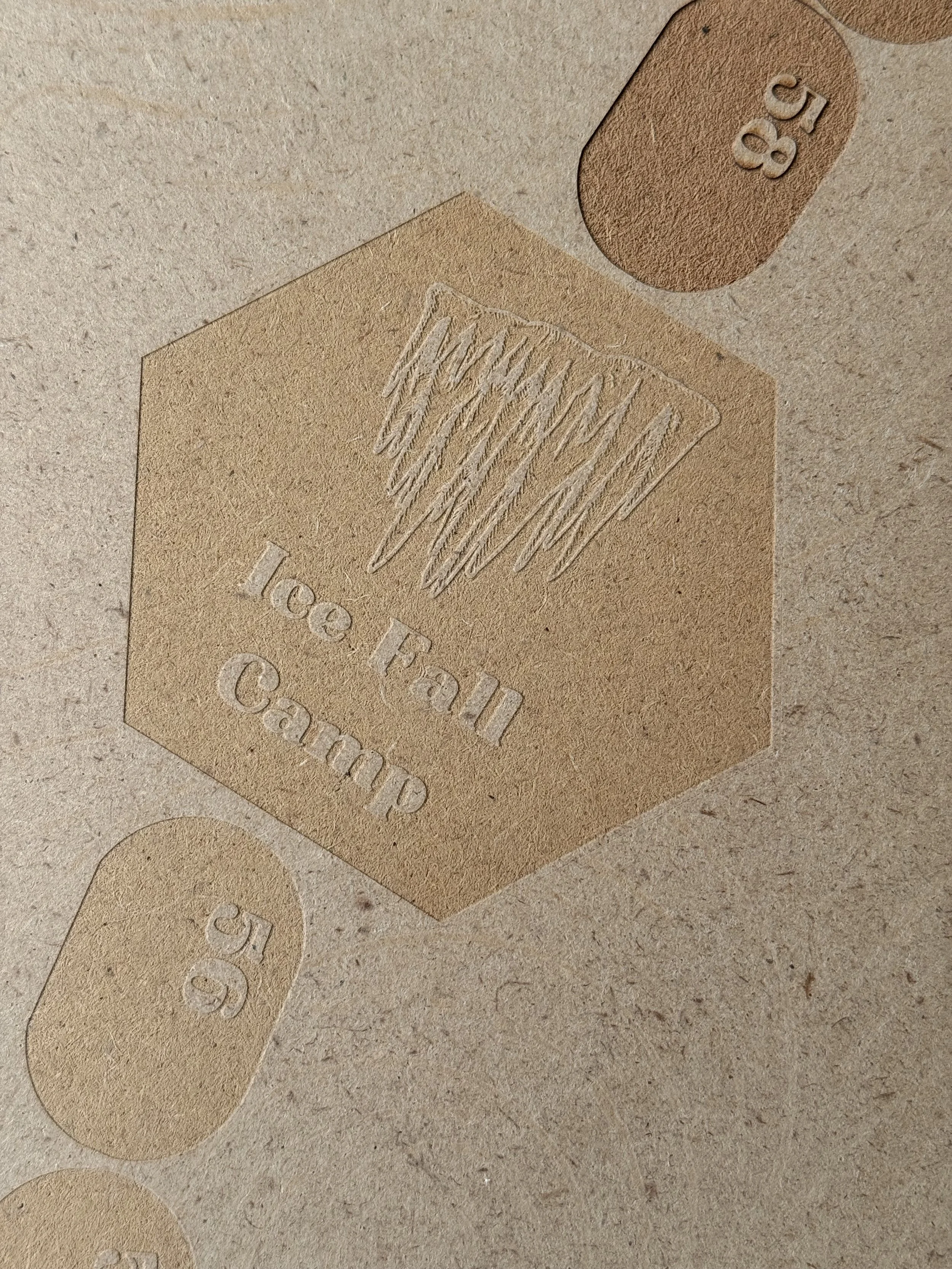 Close-up view of light brown paper tags with embossed and printed text, including 'C58' and 'Lowell'.