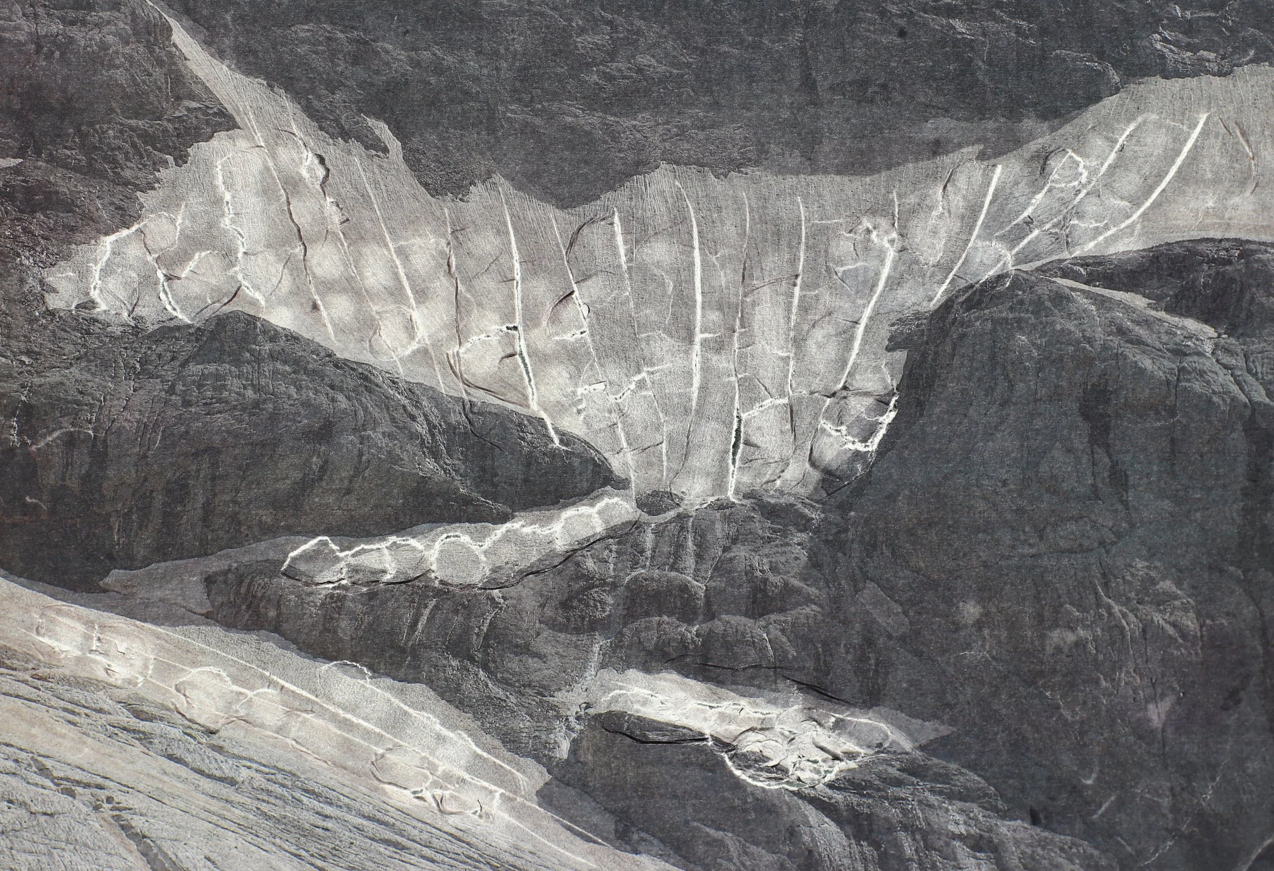 Close-up view of layered rock formations with various shades of gray and white, showcasing natural geological patterns.