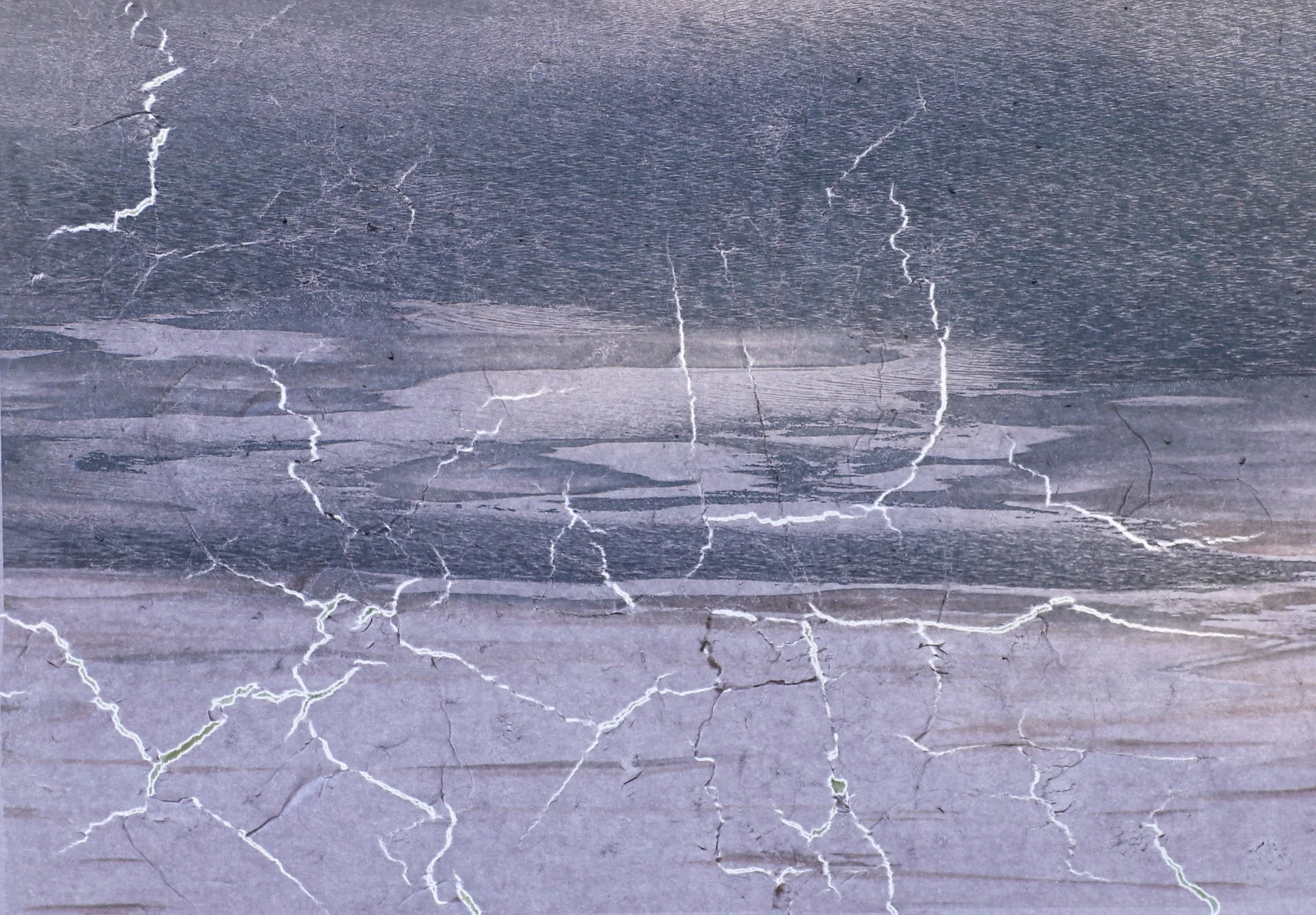 Close-up of a dark gray stone surface with white natural fracture lines.