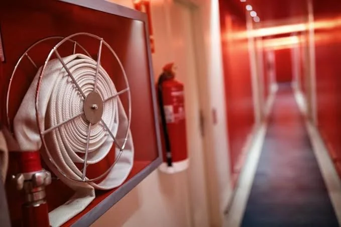 Estintore con tubo di sicurezza in un corridoio