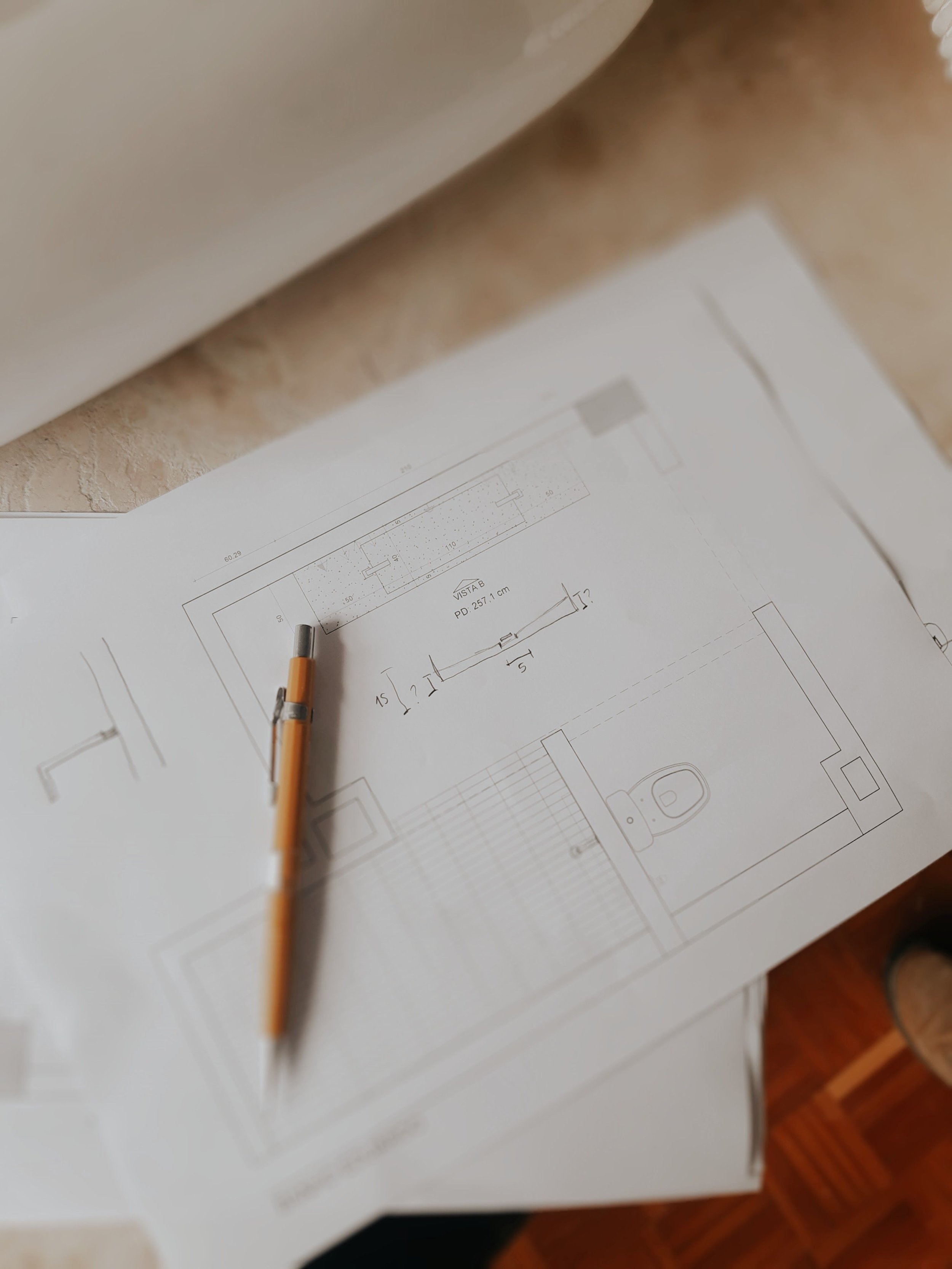 Disegno di un progetto architettonico con svariate misure e dettagli, foglio di carta con matita e penna sopra.