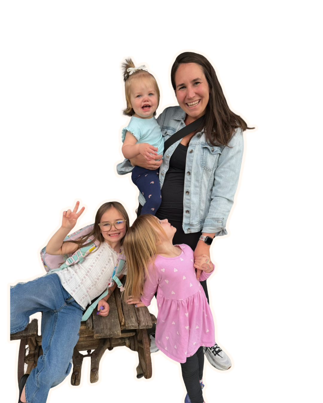 A woman smiling and holding a crying toddler, with two young girls nearby making peace signs and smiling.