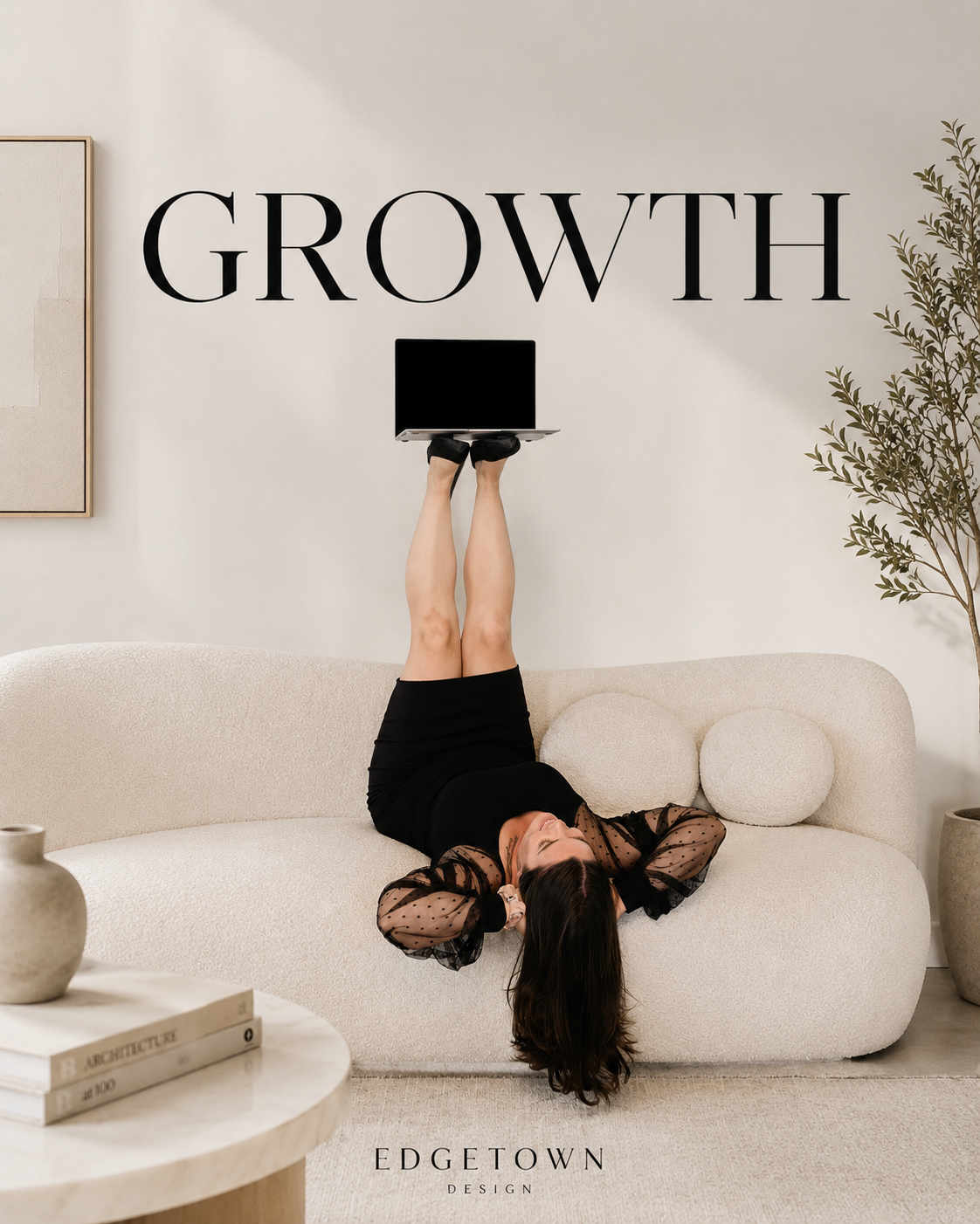 A woman lying on a cream-colored sofa with her legs in the air, holding a laptop above her. Behind her, the word 'GROWTH' is on the wall in bold black letters. The room has a minimalist decor with neutral tones, a potted plant, and a small table with books.