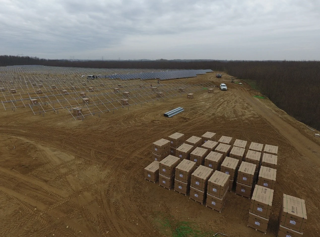 Mounting structures, photovoltaic modules and construction equipment at a utility-scale solar installation site.