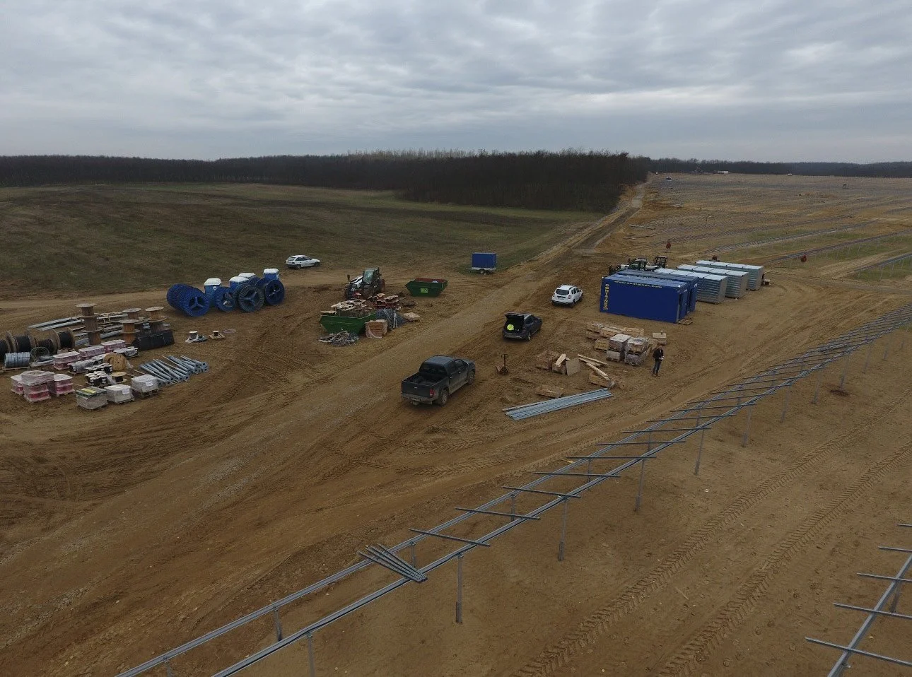 An active solar construction environment demonstrating coordinated materials, machinery and installation capacity.