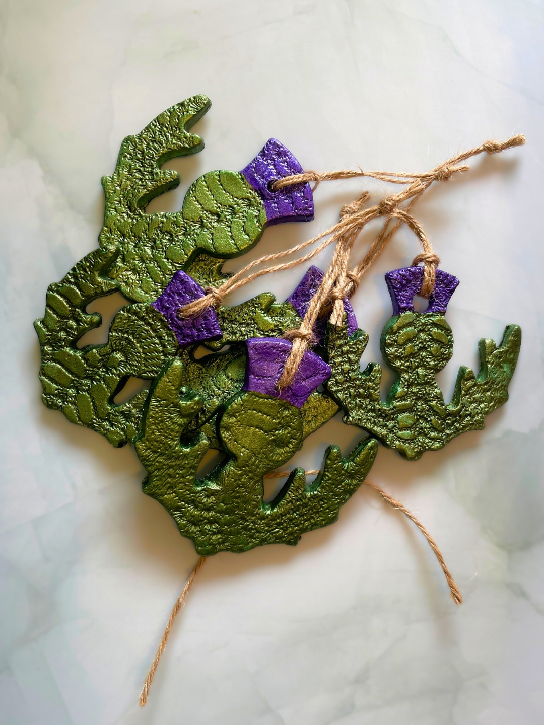 Decorative green and purple faux leaves with purple bows and tied with twine.