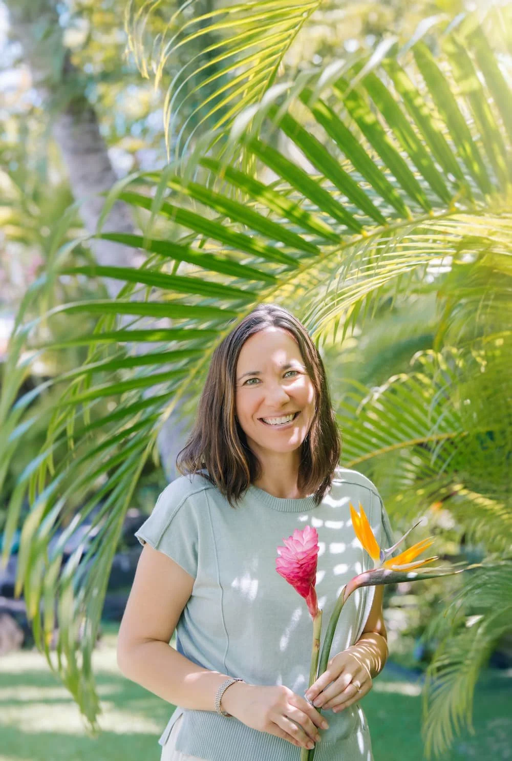 Nurse practitioner Lani Hubbard smiling outdoors among tropical foliage