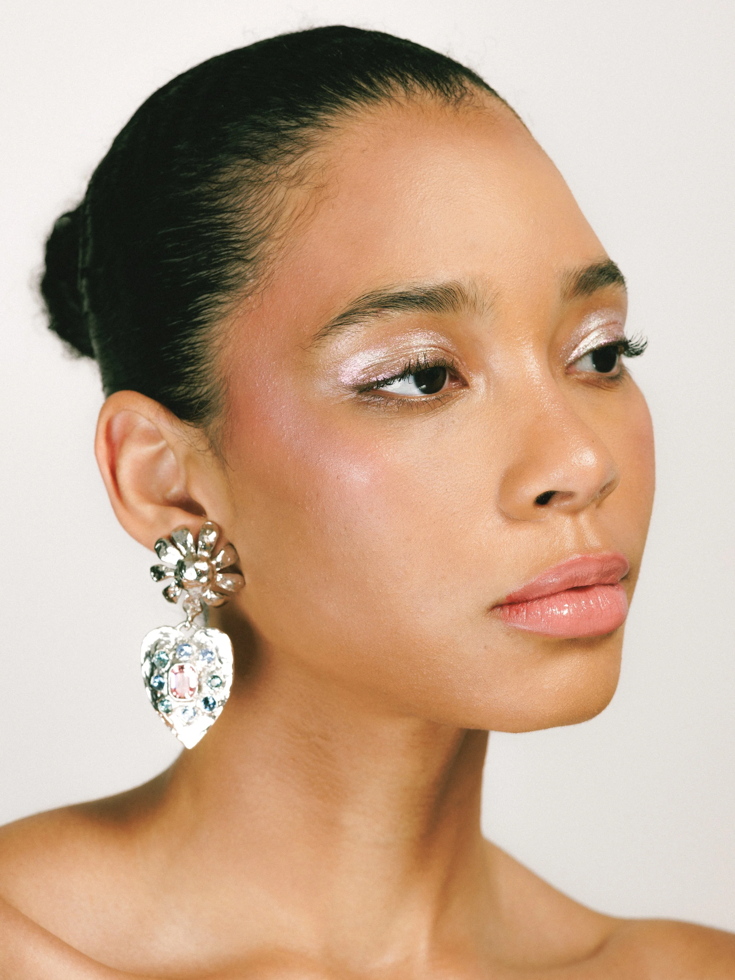 Close-up portrait of a fashion model showcasing jewelry and makeup.