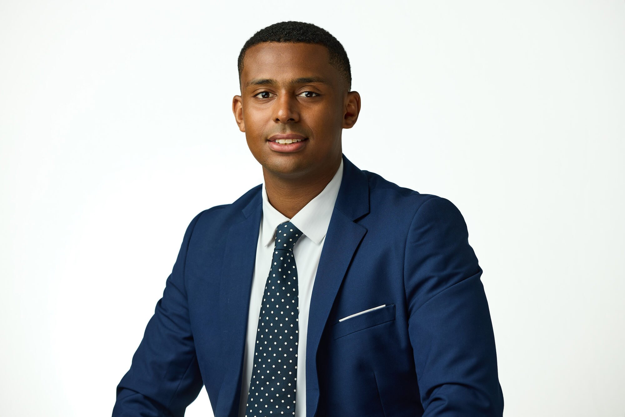 Business headshot in a navy suit and tie, white background, New York corporate session