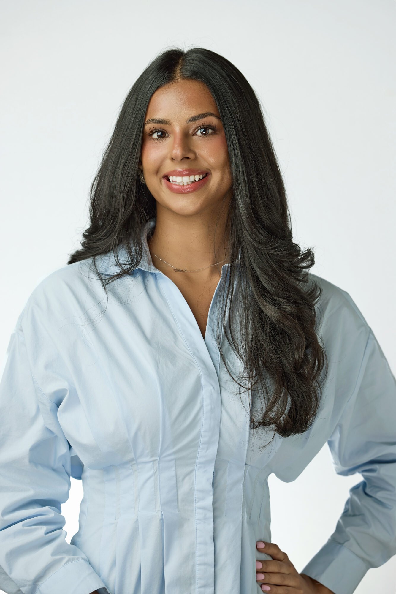 Corporate headshot in a light blue shirt, white background, Manhattan on-location session