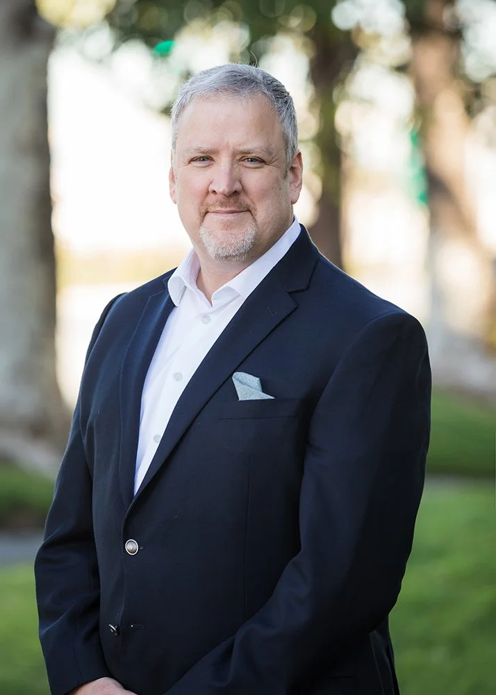 executive in navy suit getting headshots in an outdoor location