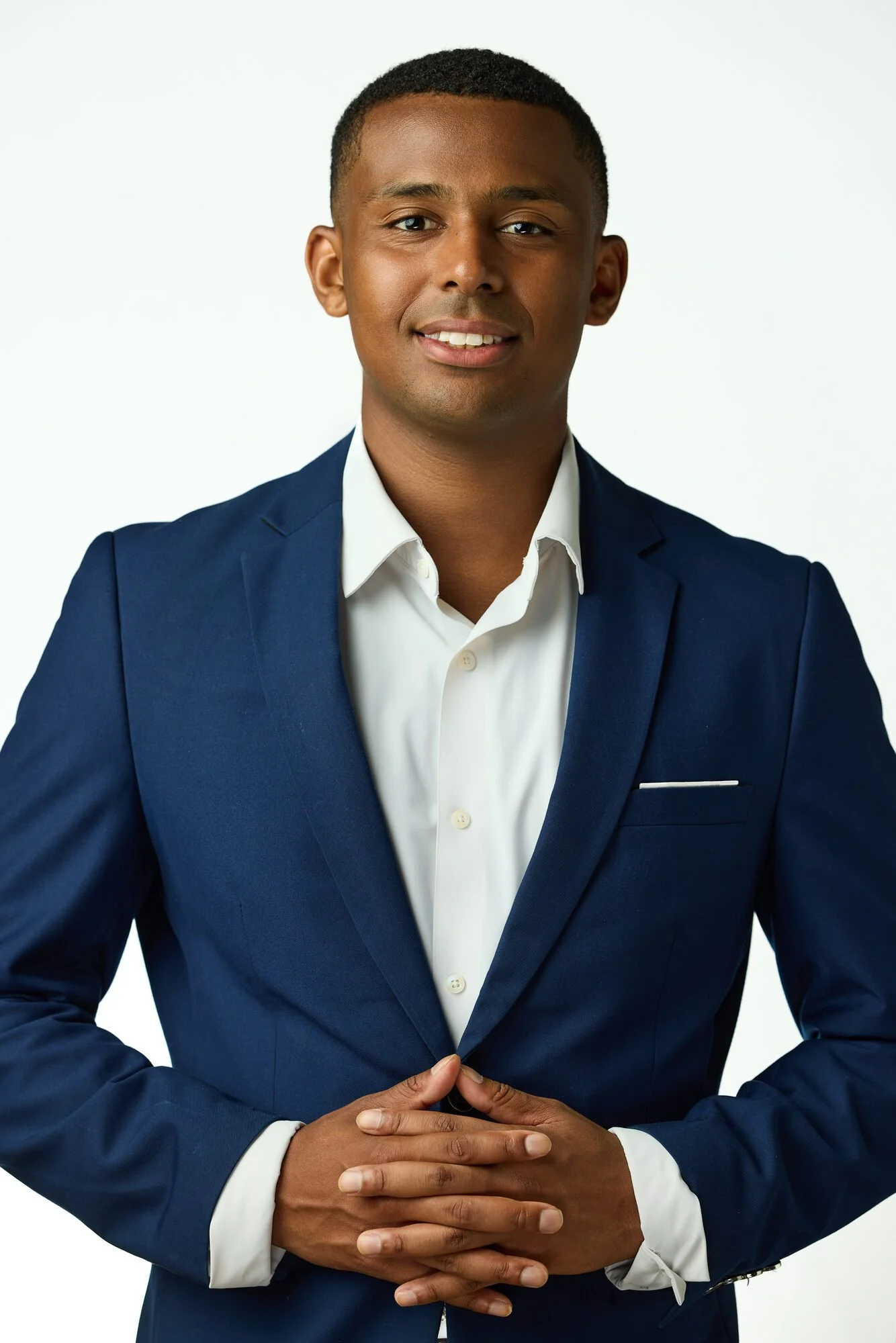 Corporate headshot of a professional in a navy suit, photographed on-location in a Manhattan office