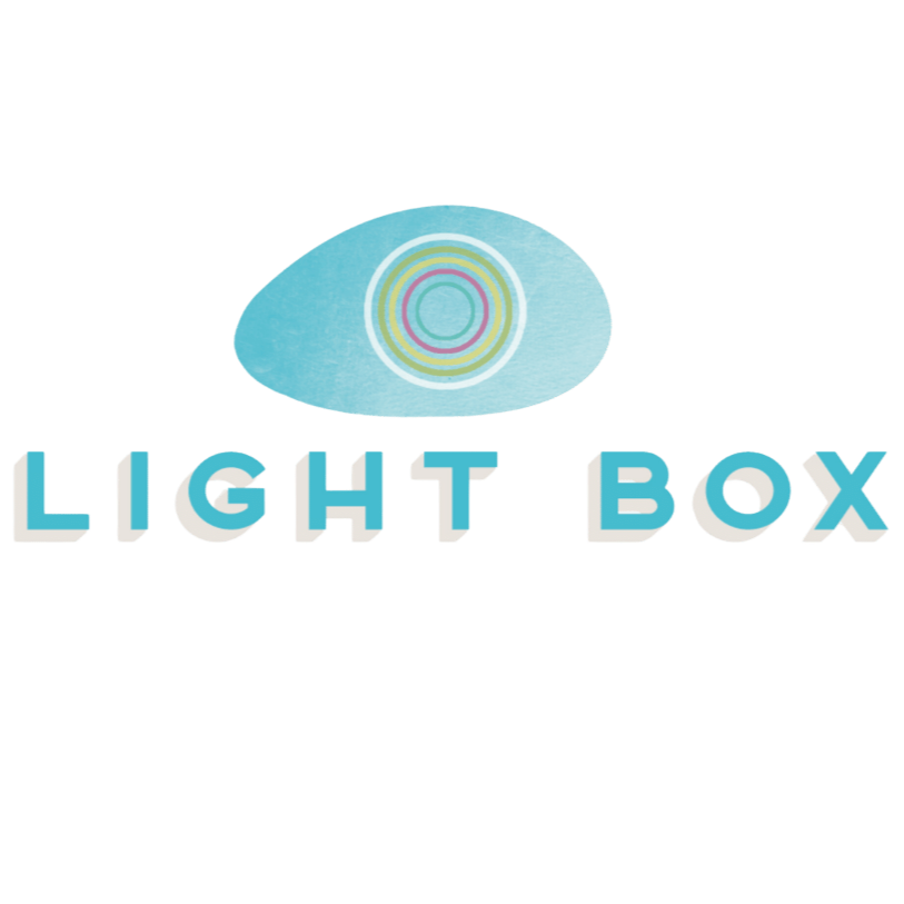A cartoon light blue eye with colorful concentric circles in the iris above the text "LIGHT BOX" in 3D blue and white letters.