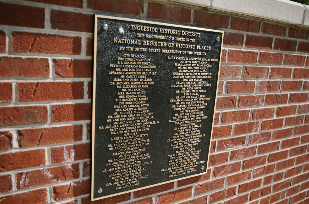Black and gold plaque on a brick wall listing names of people in the Ingleside Historic District, part of the National Register of Historic Places.