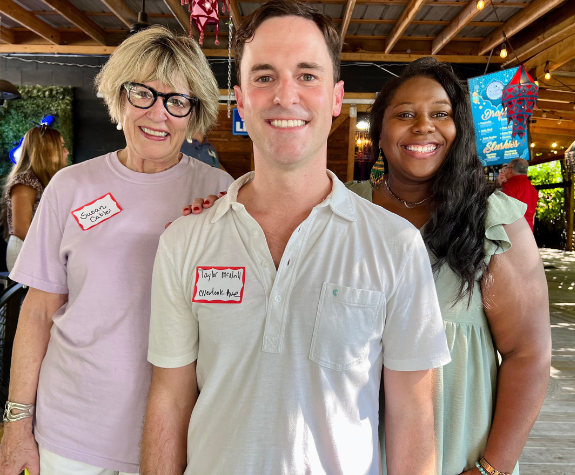 Neighbors enjoying our annual "Back to School" supply drive; three smiling people standing together at Society Garden, raising money and giving back to our community.