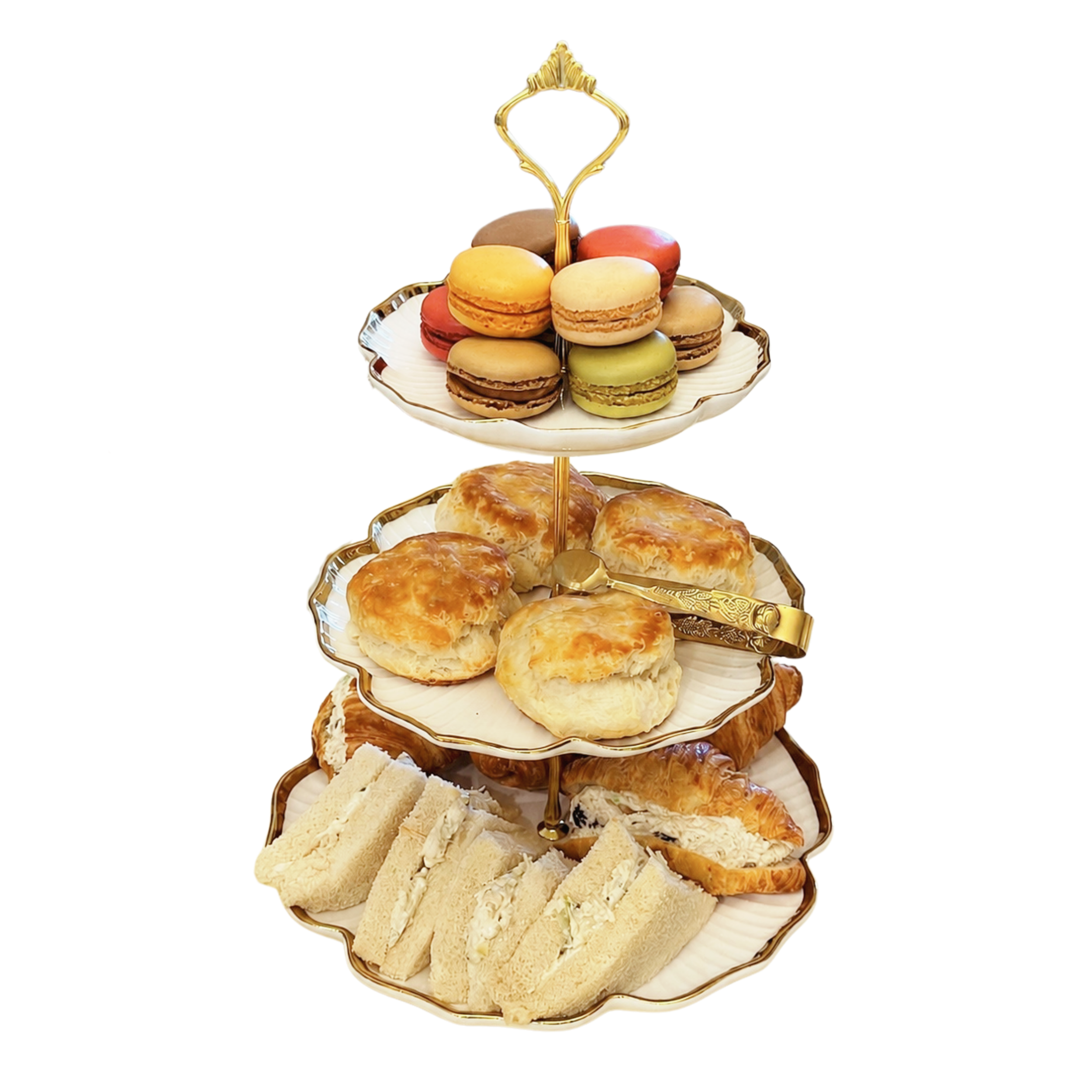 Three-tiered appetizer tray with assorted macarons, sandwiches, pastries, and puffs.