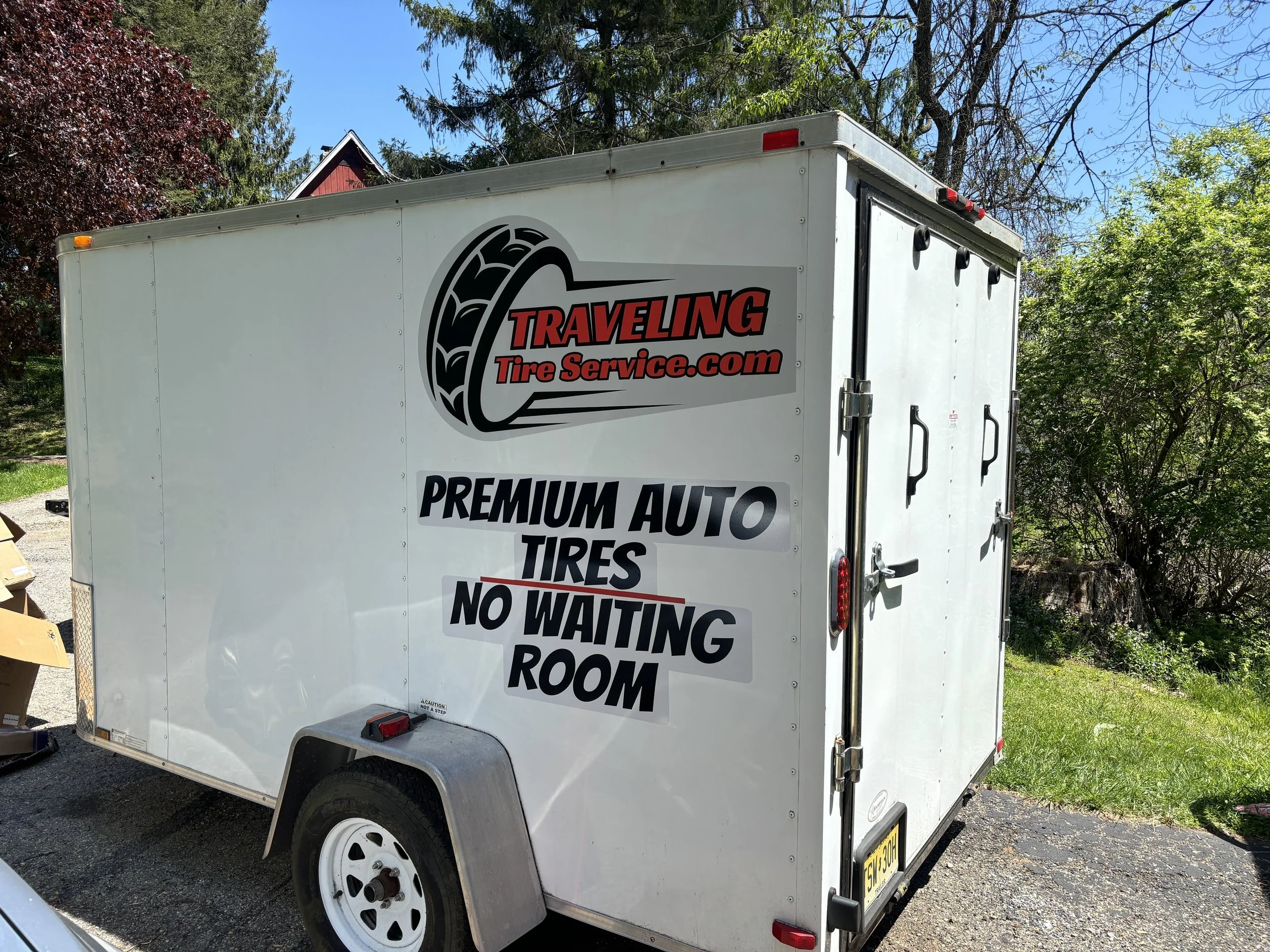 White trailer with Traveling Tire Service logo, providing mount and balance on location