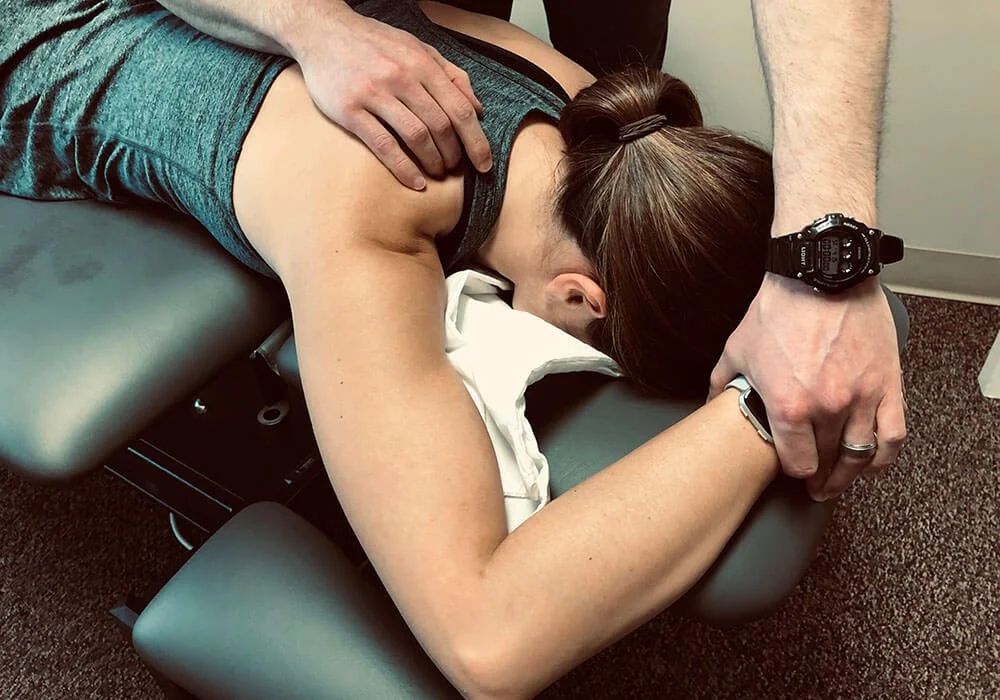 Physical therapist guiding a patient through shoulder rehabilitation
