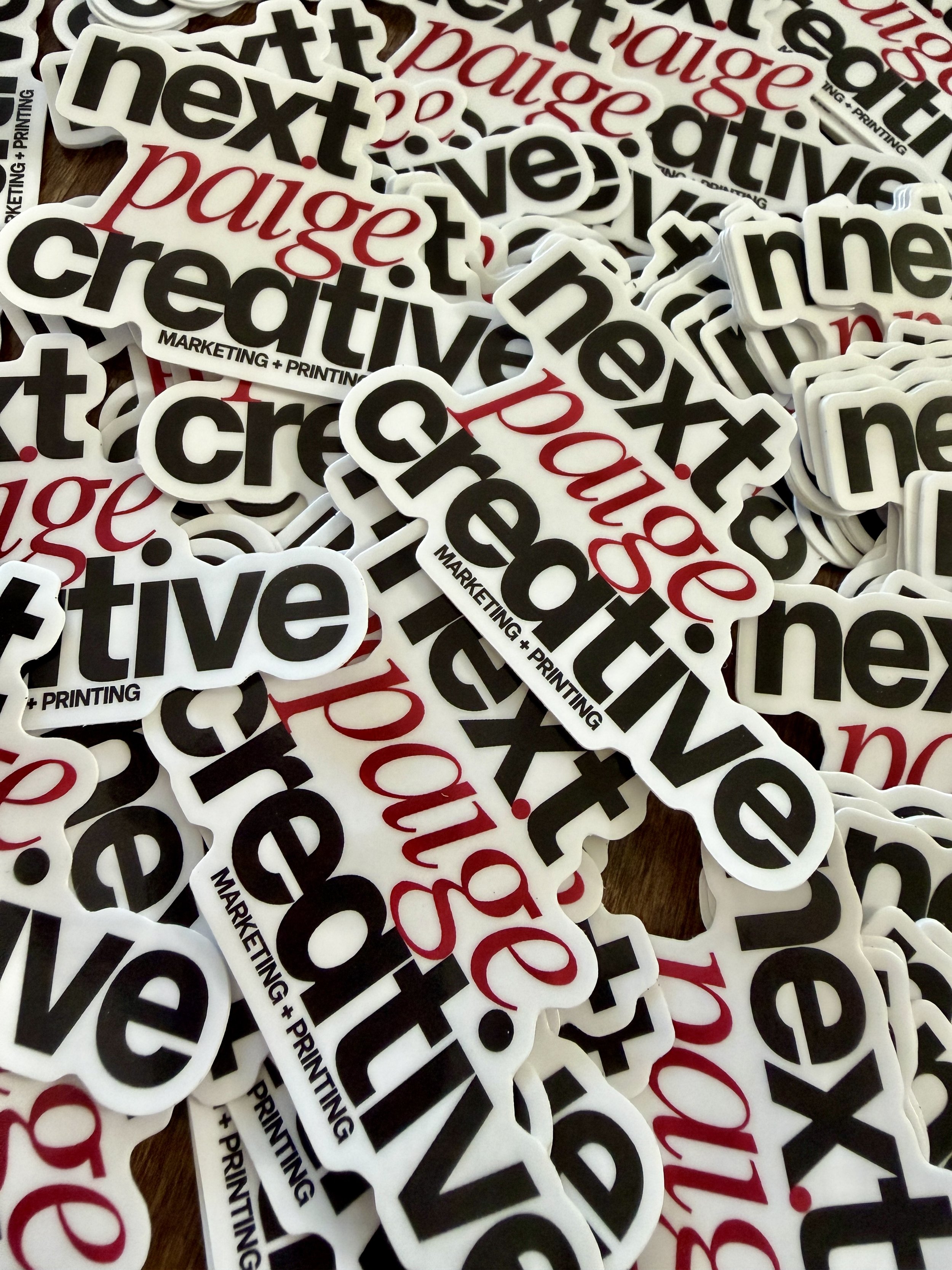 A collection of stickers with the words 'next', 'positive', and 'payout', along with 'MARKETING + PRINTING' printed on them.