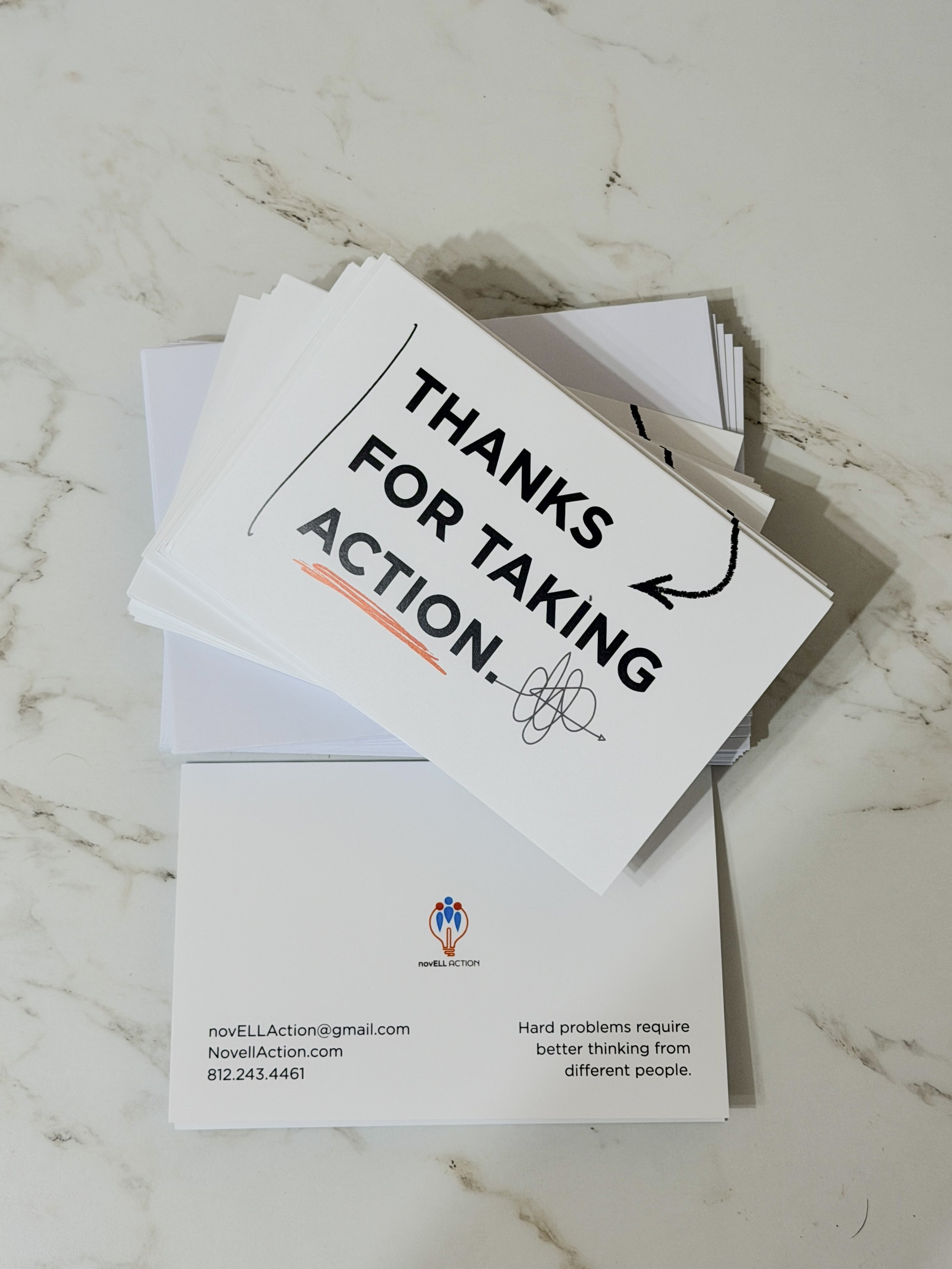 A stack of printed papers with the top sheet displaying the message: "THANKS FOR TAKING ACTION." At the bottom of the sheet, there is an email address, novELLAaction@gmail.com, an organization name, NovEll Action, and a phone number, 812.243.4461. Th