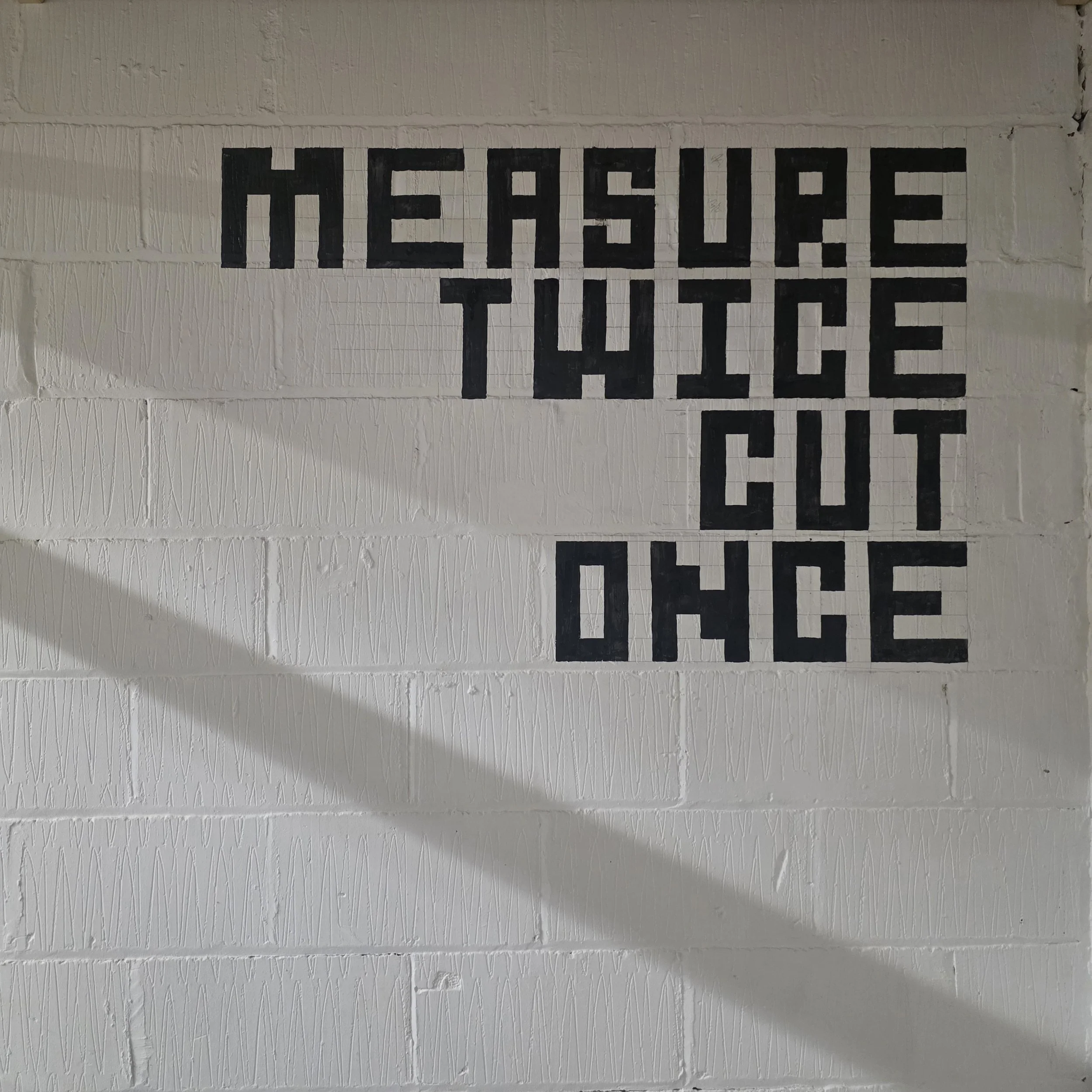 A white brick wall with the words 'HEAT SOURCE' painted in black capital letters.