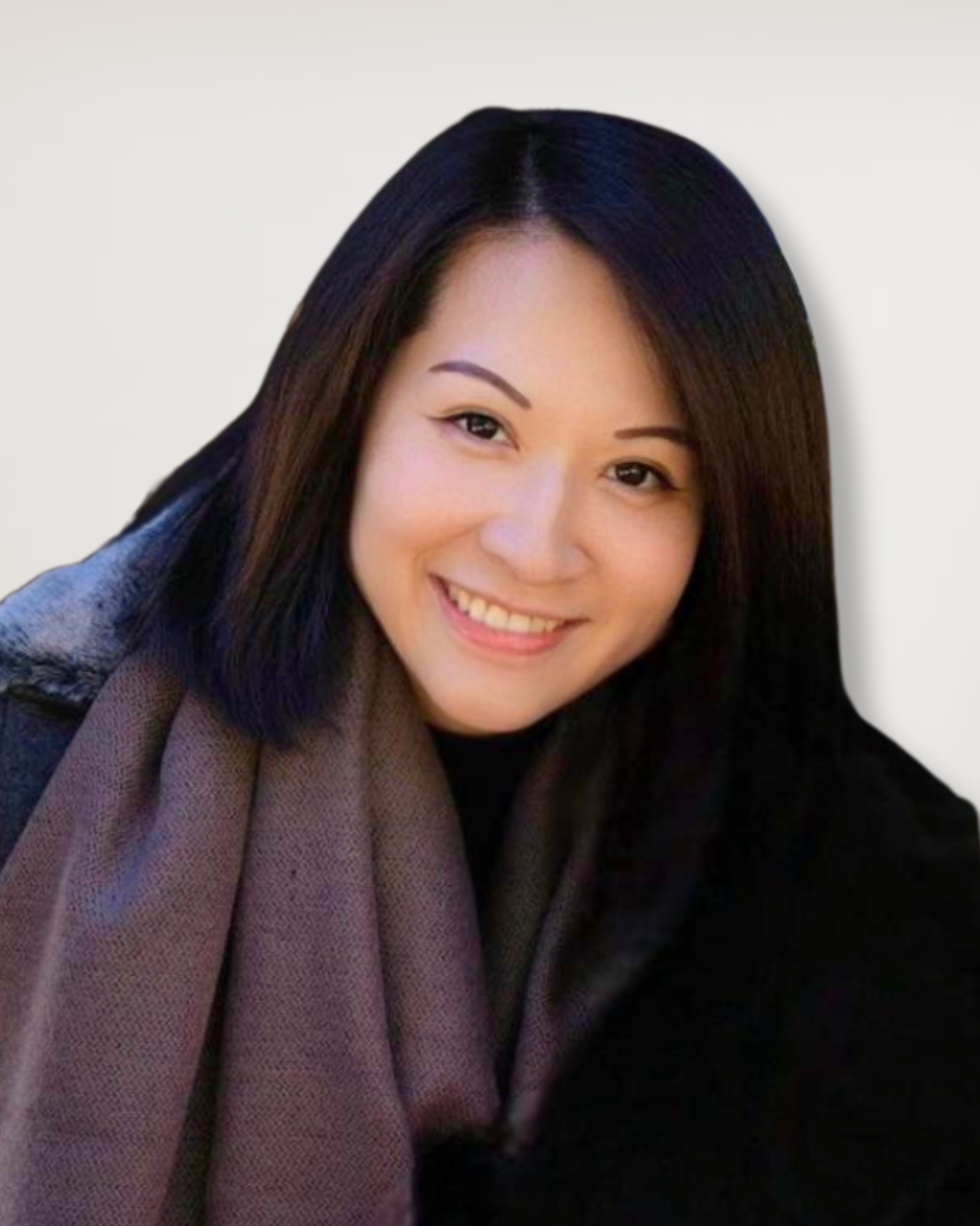 A woman with long dark hair smiling, wearing a dark coat and a brown scarf against a white background.