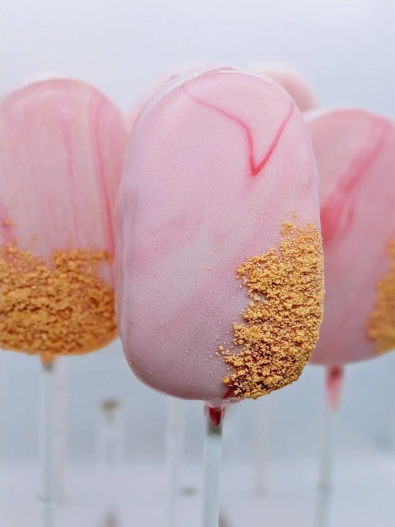 Strawberry Cheesecake cakesicles with pink marble dip