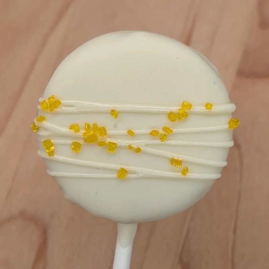 Lemon cake pop with drizzle and yellow sugar sprinkles