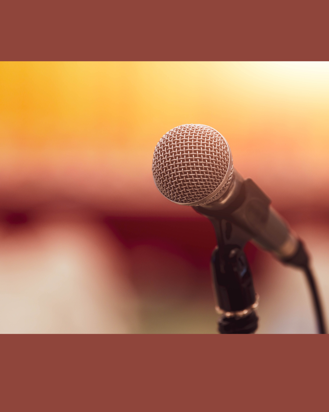 Close-up of a microphone with a blurred background of warm colors.